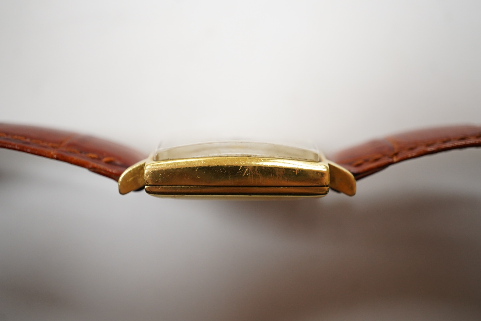 A gentleman's 18k Zenith Automatic square dial wrist watch, with baton numerals and date aperture, on an associated leather strap, case diameter 30mm. Condition - poor.